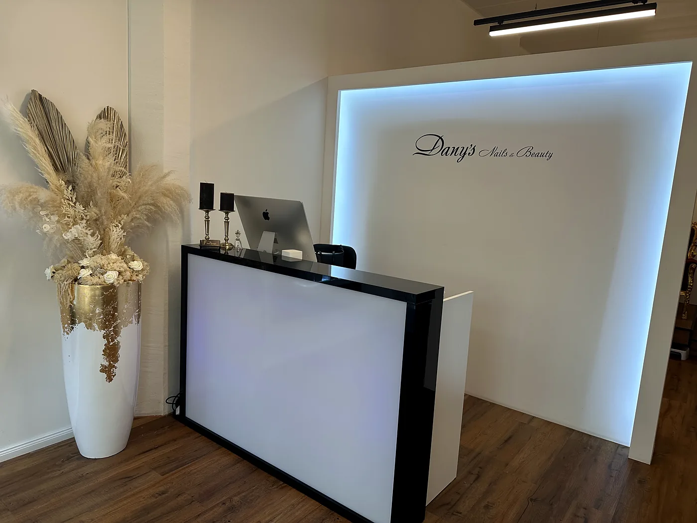 Empfangstheke mit beleuchtetem Logo von Dany's Nails und Beauty